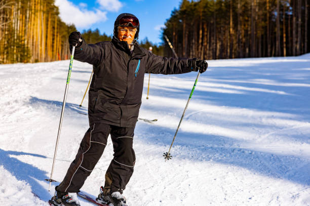 Senior Caucasian man, enjoys the ski ride with his grandson at the ski slope