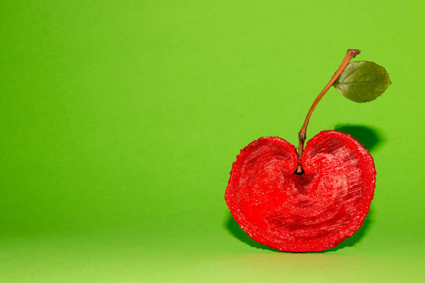 cherry in the lower right corner creative concept painted wood added stem and leaf that looks like cherry amazing nautral phenomenon on a green background
