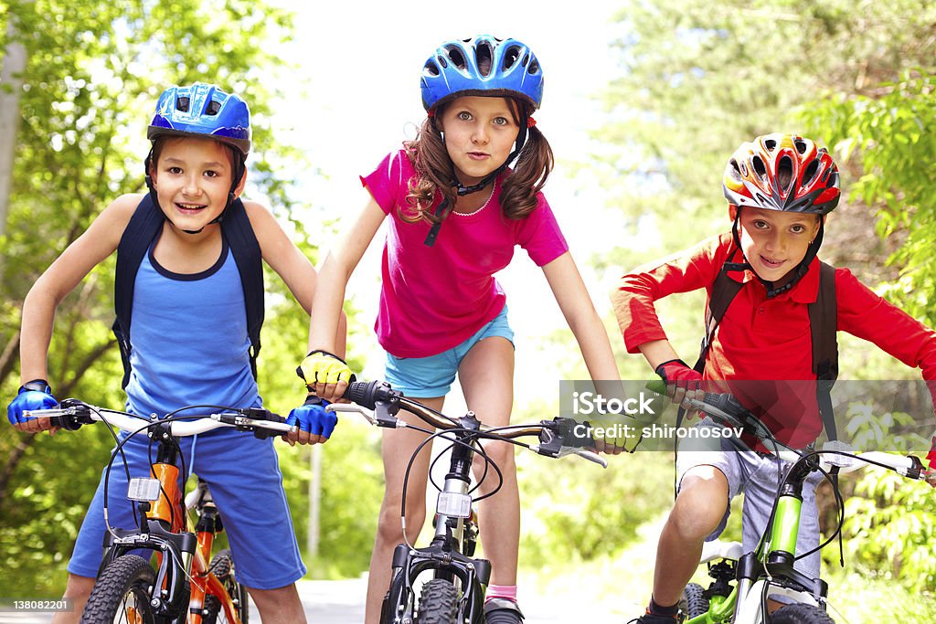 Children on bikes Portrait of three little cyclists riding their bikes Child Stock Photo
