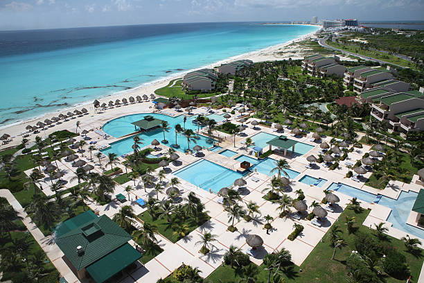 Man contemplating the sea from a large swimming pool on a cliff.