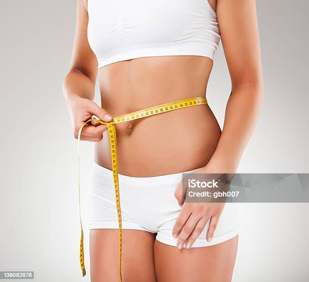 Slim Woman Measuring Her Body Stock Photo - Download Image Now - 20-24 Years, 20-29 Years, Abdomen