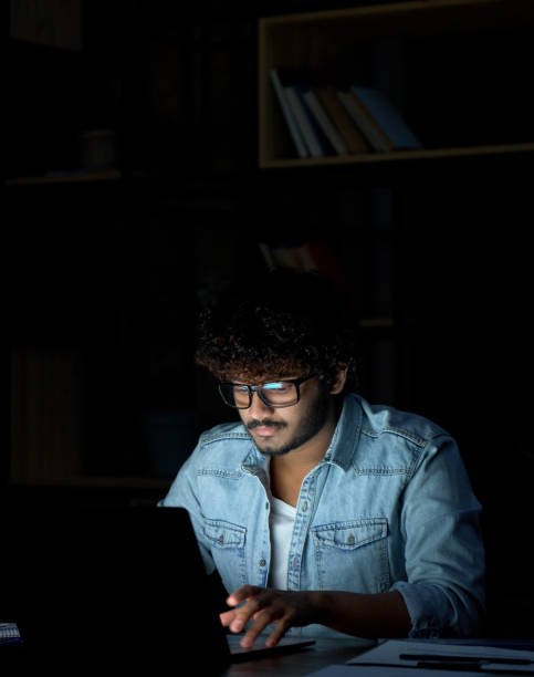 istock Young indian businessman student working online at night using laptop. 1380857525