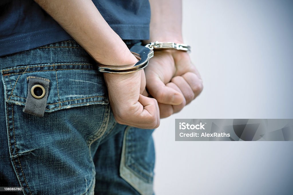 teenager under arrest Young man in handcuffs Teenager Stock Photo