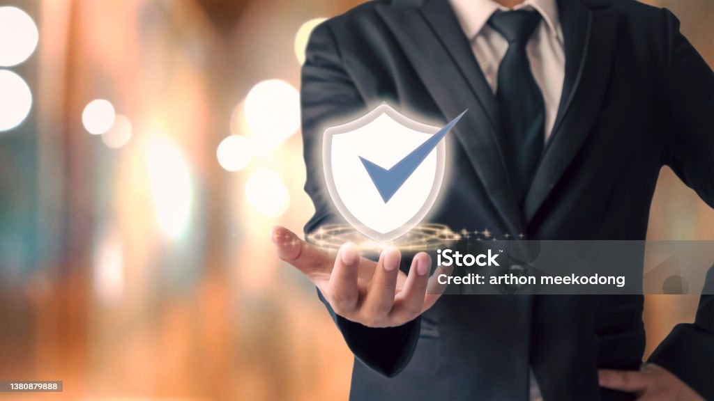 businessman holding shield icon and orange pokemon background Cybersecurity concept safe your data. Icon Symbol Stock Photo