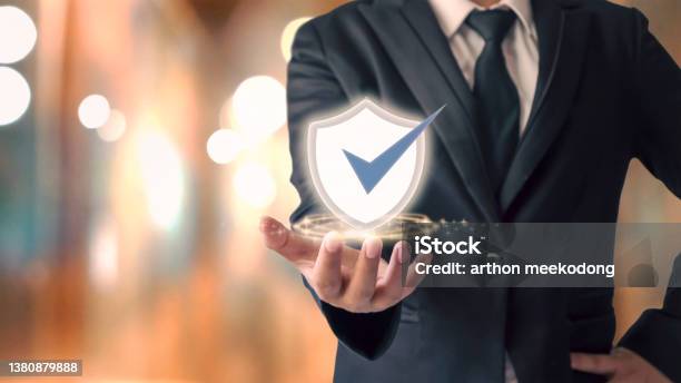 Businessman Holding Shield Icon And Orange Pokemon Background Cybersecurity Concept Safe Your Data Stock Photo - Download Image Now
