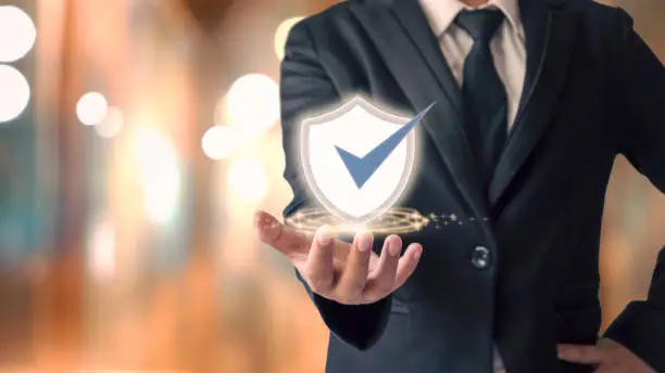 businessman holding shield icon and orange pokemon background Cybersecurity concept safe your data.