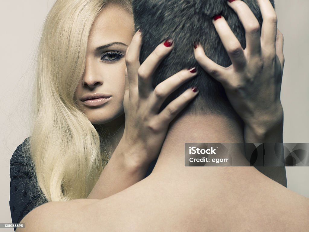 Blonde Caucasian woman grabbing back of man's head sensually Beautiful passionate girl hugging a man by the neck 20-24 Years Stock Photo