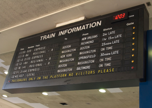 Train schedule information board hanging in station.