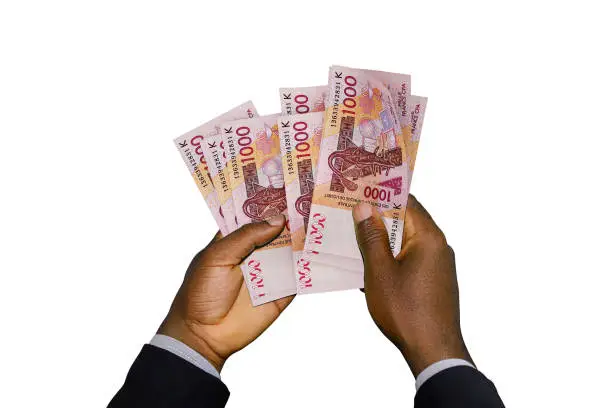 Photo of Black Hands in suit holding 3D rendered CFA Franc notes