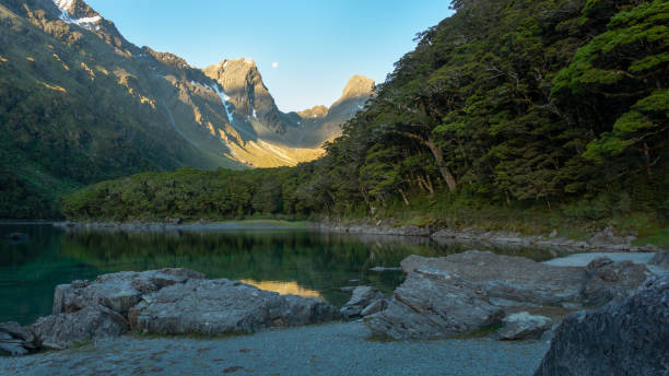 луна поднимается над горами у озера маккензи на routeburn track, одной из величайших прогулок новой зеландии. - routeburn falls new zealand mountain beauty in nature стоковые фото и изображения