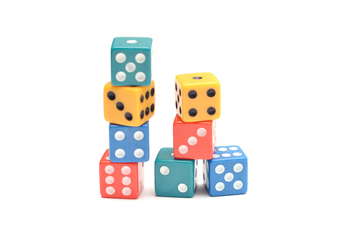 Closeup of stacks of multi-coloured dice on a white background;