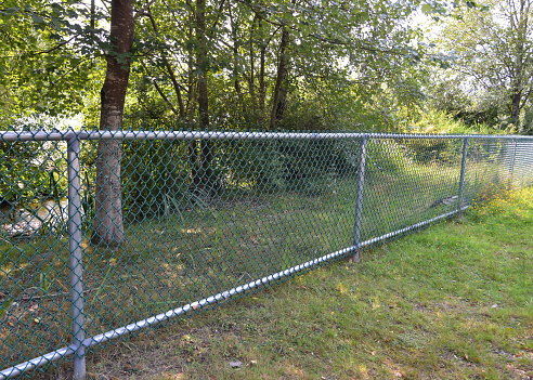 Closeup of a new chain link fence in a park.