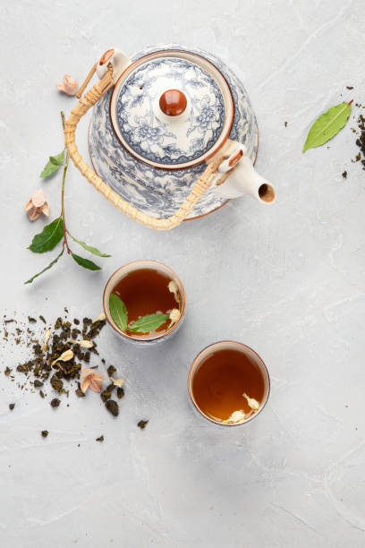 istock Asian teapot with herbal tea on light background. 1380969280