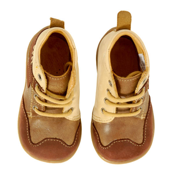 Single baby shoe on wooden shelving: red leather with cutout design.