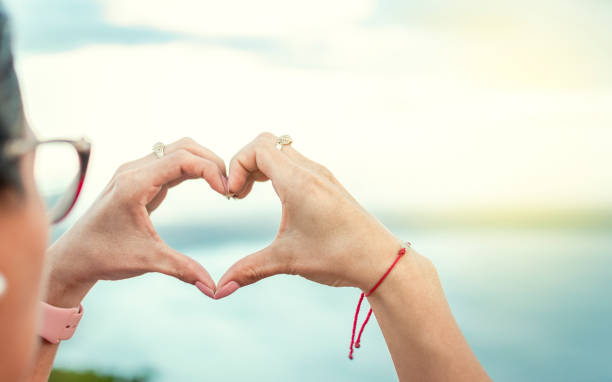 istock Hands together in a heart shape, woman's hands together in a heart shape, hands making a heart shape 1380979981