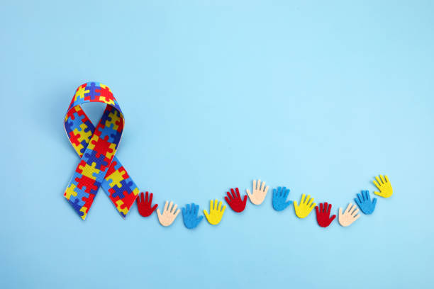 青い背景にカラフルな手を持つ自閉症啓発コンセプト。トップビュー - social awareness symbol ストックフォトと画像