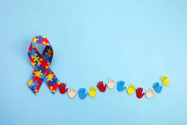 Photo of Autism awareness concept with colorful hands on blue background. Top view