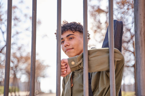 istock Latin smiling man behind fence 1380989236