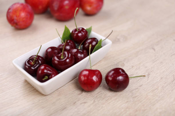 istock Fresh cherry in white dish on wooden background 1381007670