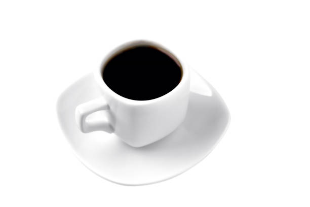 white cup of coffee on a white saucer; on a white background; isolate, close-up, angle view from above