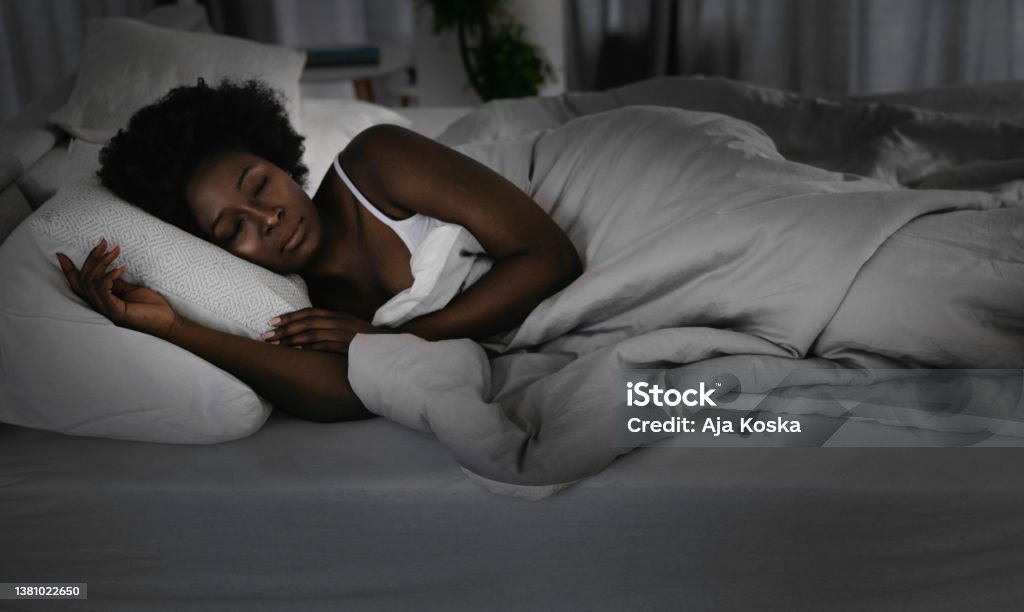 Young beautiful woman sleeping. Young beautiful woman sleeping during the night. Bed - Furniture Stock Photo