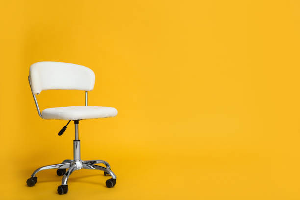 istock Modern office chair on yellow background. Space for text 1381038599