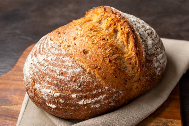 istock Sourdough bread on linen cloth on brown chopping board. 1381038614