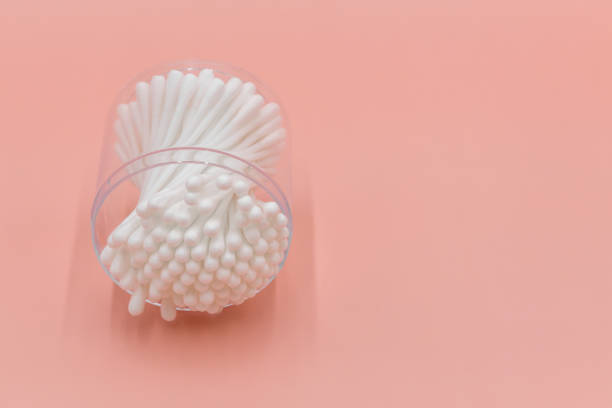 Cotton buds in box on a white background, Top view flat lay swabs cotton buds on orange background with copy space.