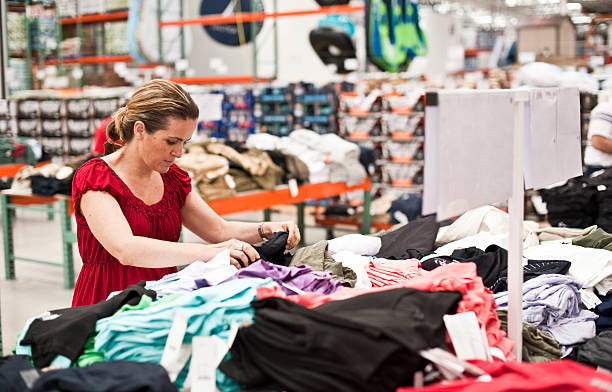 shopping for clothes stock photo woman buying clothes at a department store megastore stock pictures, royalty-free photos & images