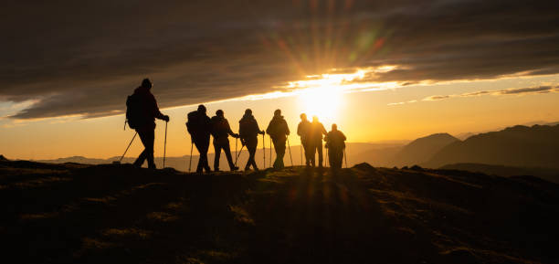 silhouettes of hikers at sunset - achievement mature adult adult mountain range imagens e fotografias de stock