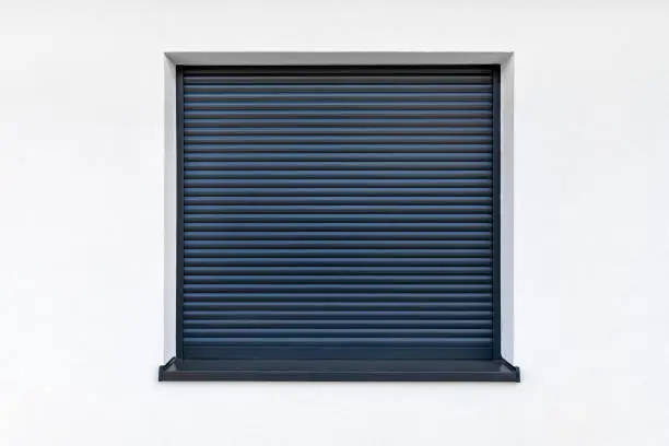 Large window in anthracite color with fully covered external blinds, view from the outside of the building.