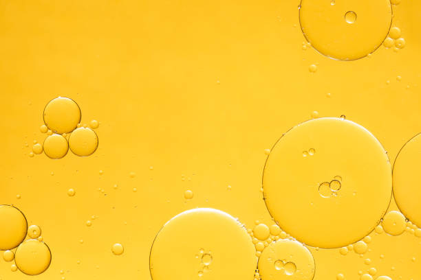 burbujas de aceite abstracto de color amarillo dorado o fondo de suero facial. - aceites esenciales fotografías e imágenes de stock