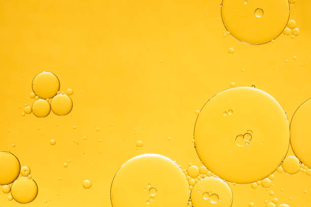 golden yellow abstract oil bubbles or face serum background. - 香精油 個照片及圖片檔