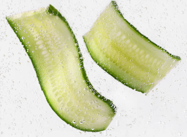 istock Sliced cucumber with water bubbles on white background. Skin moisturizing cosmetics concept. 1381120448