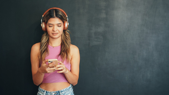 Young woman listening music from her phone