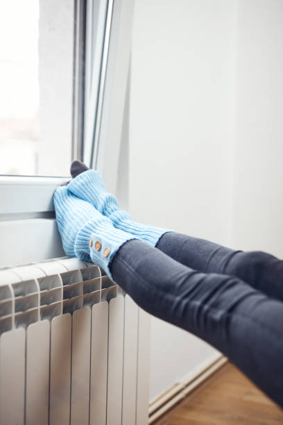 istock Woman's feet with woolen socks, enjoying inside home on the radiator. 1381171601