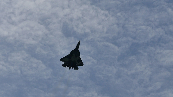 Moscow Russia AUGUST, 26, 2015 Dramatic image of the black silhouette of a Russian fighter plane in the sky. Copy space. Sukhoi Su-57 Felon stealth multirole fighter jet airplane of Russian AirForce