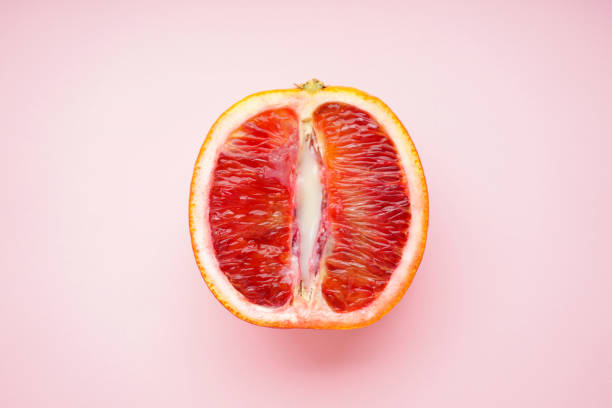 Juicy blood orange and condensed milk on a pink background, top view. Sex concept 18+ stock photo