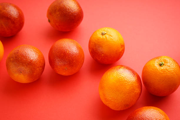 istock Ripe blood oranges on a red background, close-up. 1381220956