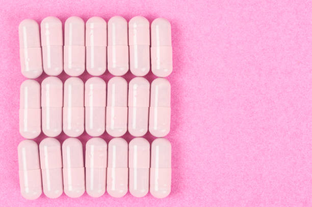 istock Pink capsule pills on pink background. 1381221020
