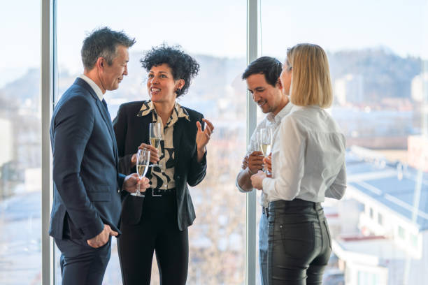 male and female executives enjoying champagne at the office party - party business toast champagne imagens e fotografias de stock