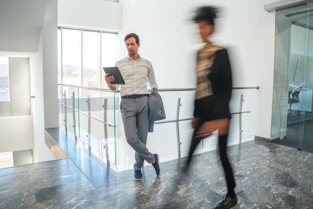 istock Smiling Businessman Using A Digital Tablet In The Office Corridor 1381248951
