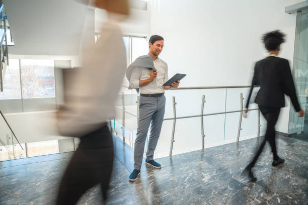 istock Smiling Businessman Using A Digital Tablet In The Office Corridor 1381248957