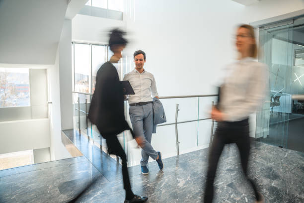 istock Smiling Businessman Using A Digital Tablet In The Office Corridor 1381248961