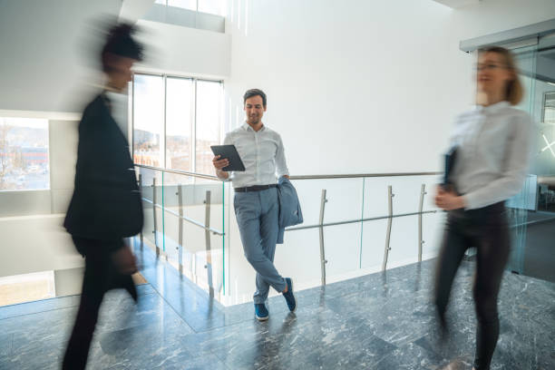 istock Smiling Businessman Using A Digital Tablet In The Office Corridor 1381248965