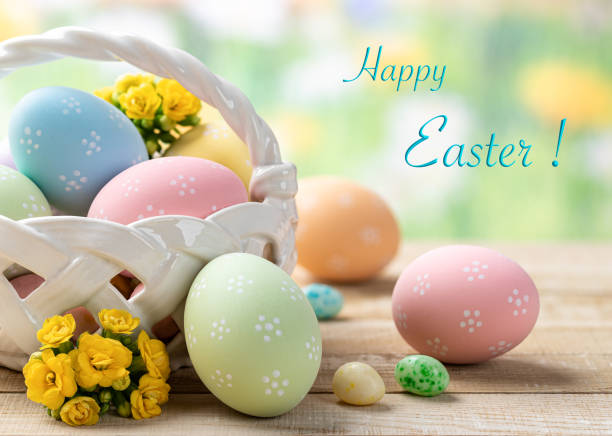 Colored easter eggs with basket and flowers Colored easter eggs with basket and flowers on a wooden table with colorful spring background and Happy Easter text egg food photos stock pictures, royalty-free photos & images