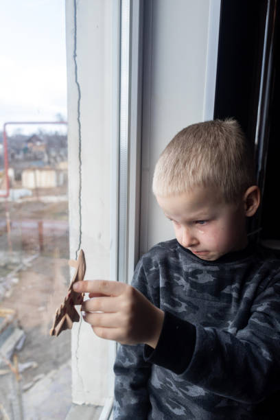 istock Child sits on the window and holding a fighter toy plane 1381263204