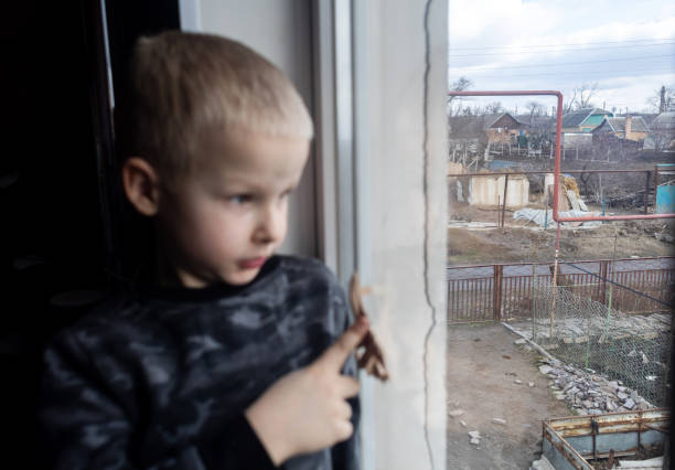 istock Child sits on the window and holding a fighter toy plane 1381263735