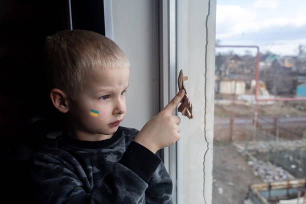 istock Child sits on the window and holding a fighter toy plane 1381264277