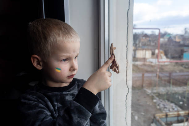 Child sits on the window and holding a fighter toy plane Child sits on the window and holding a fighter toy plane military attack photos stock pictures, royalty-free photos & images